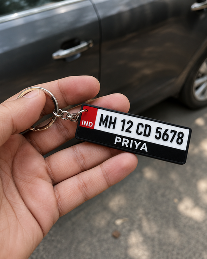 Number plate keychain held in hand beside a car